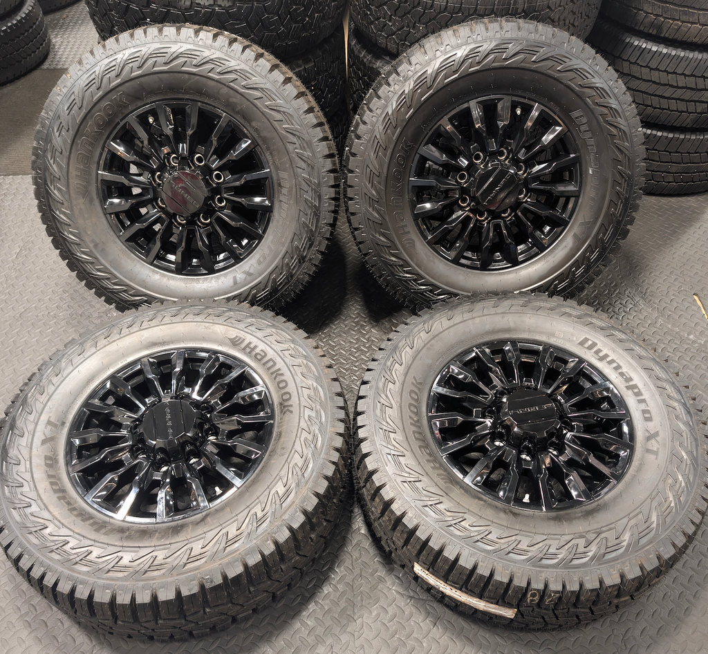 OEM 18” Gloss Black GMC Sierra / Chevrolet Silverado 2500HD & 3500HD Wheels wrapped in Hankook Dynapro XT tires.