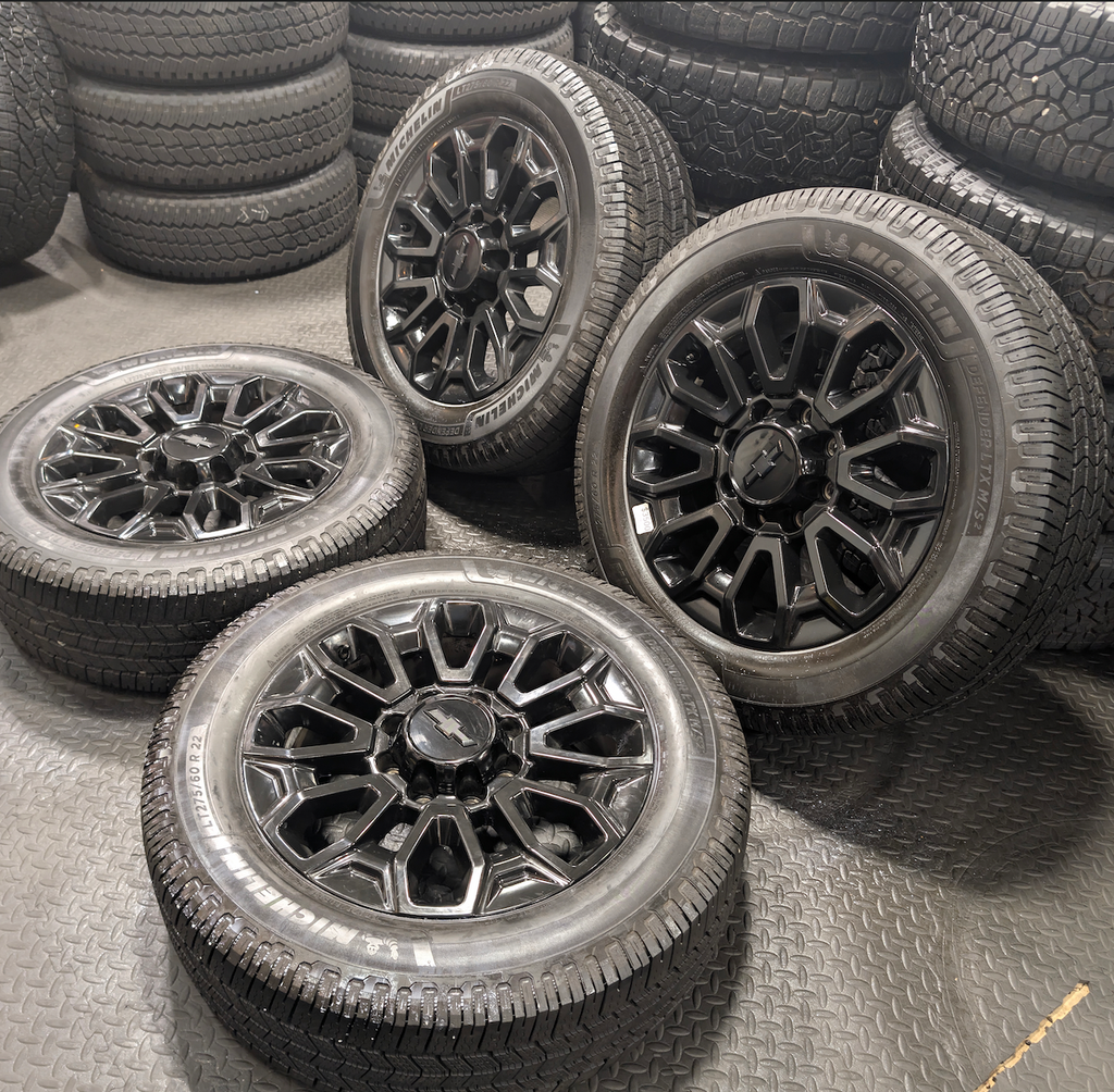 OEM 22” Gloss Black Chevrolet Silverado 2500HD / 3500HD Wheels wrapped in Michelin Defender LTX tires.