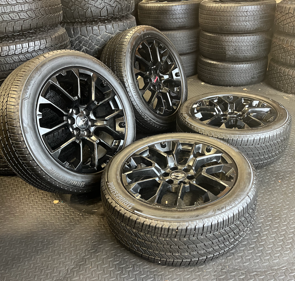OEM 22” Gloss Black Replica Wheels wrapped in Bridgestone tires.