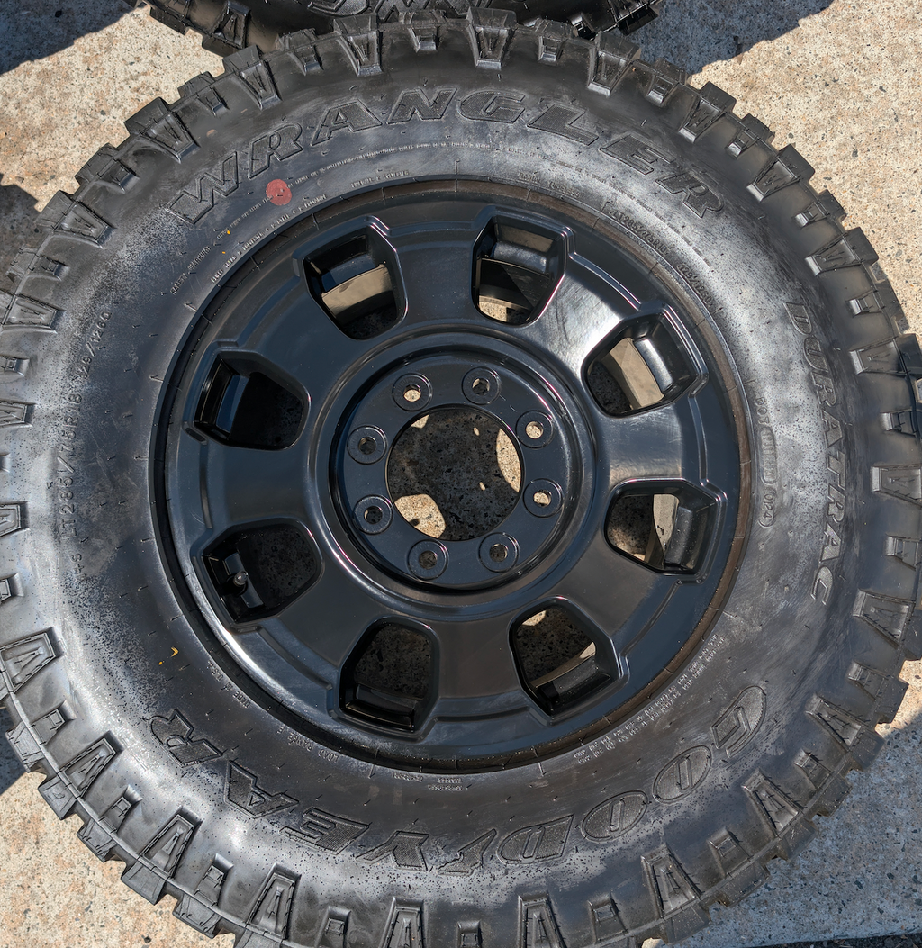 OEM 18” Ford F-250 / F-350 Tremor Wheels with Matte Black Finish wrapped in Goodyear Wrangler Duratrac tires.