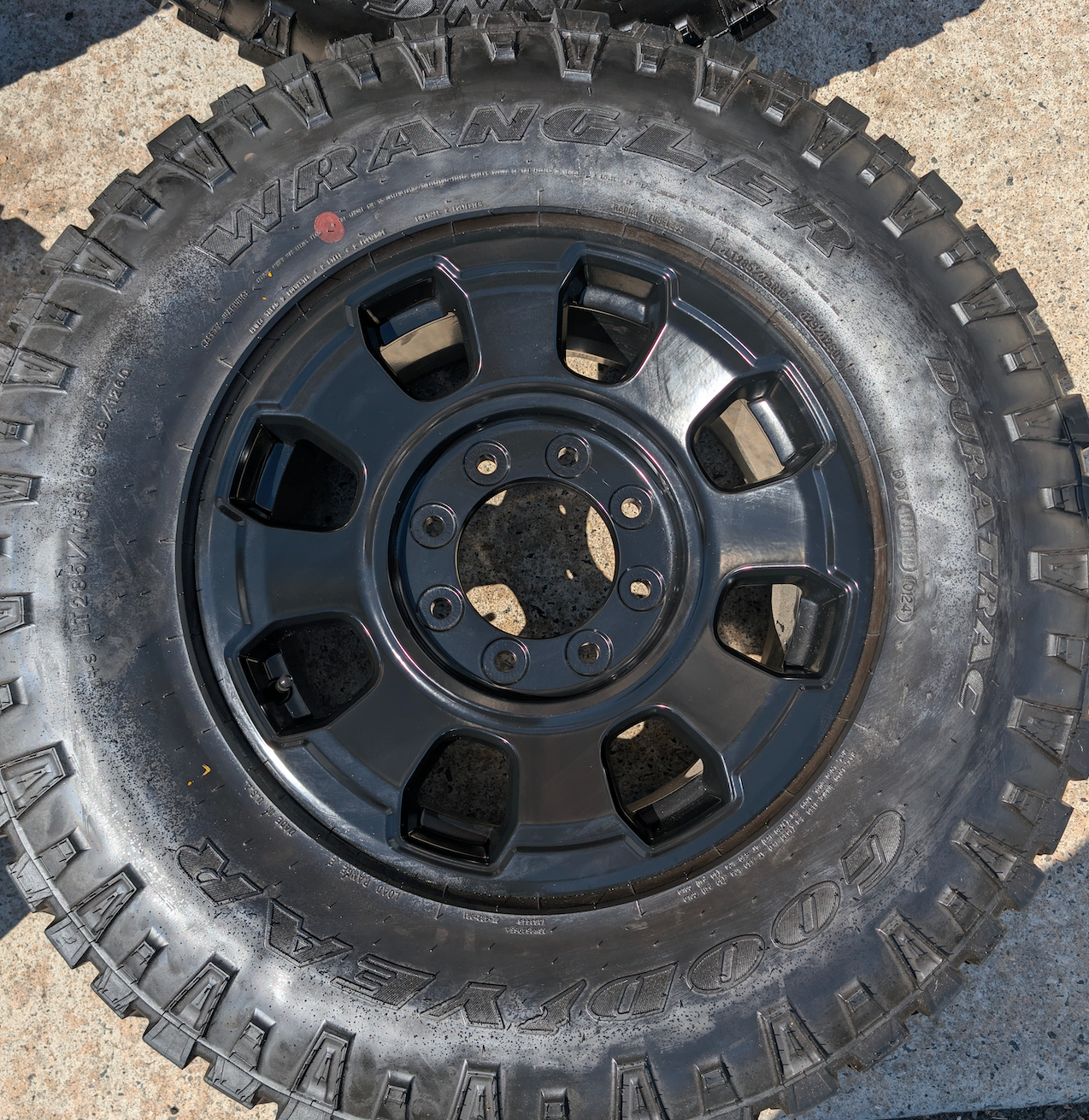 OEM 18” Ford F-250 / F-350 Tremor Wheels with Matte Black Finish wrapped in Goodyear Wrangler Duratrac tires.