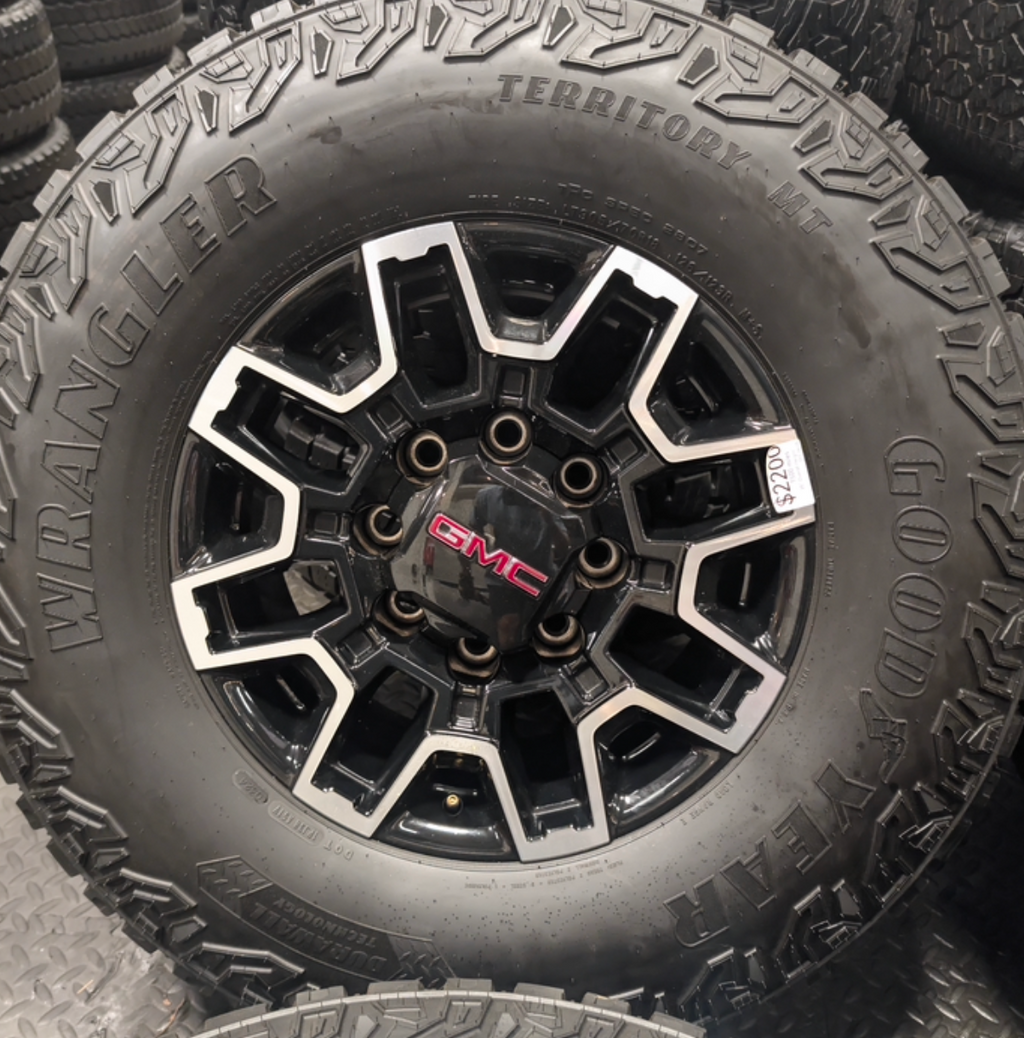 OEM 18” GMC Sierra 2500HD AT4X Black Wheels wrapped in Goodyear Wrangler Territory M/T tires.