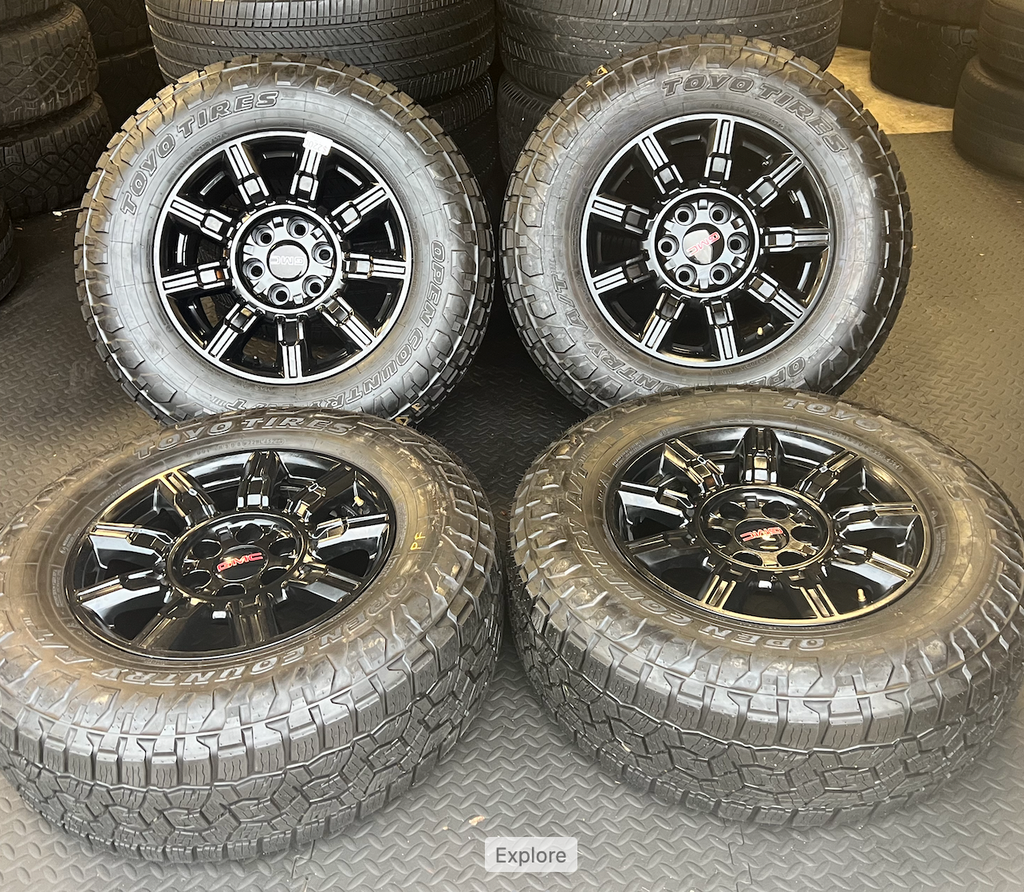 OEM 18” Gloss Black Wheels wrapped in Toyo Open Country A/T tires.