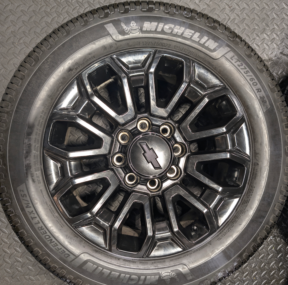 OEM 22” Gloss Black Chevrolet Silverado 2500HD / 3500HD Wheels wrapped in Michelin Defender LTX tires.