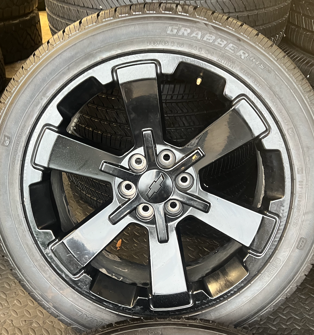 OEM 22” Gloss Black Wheels wrapped in General Grabber tires.