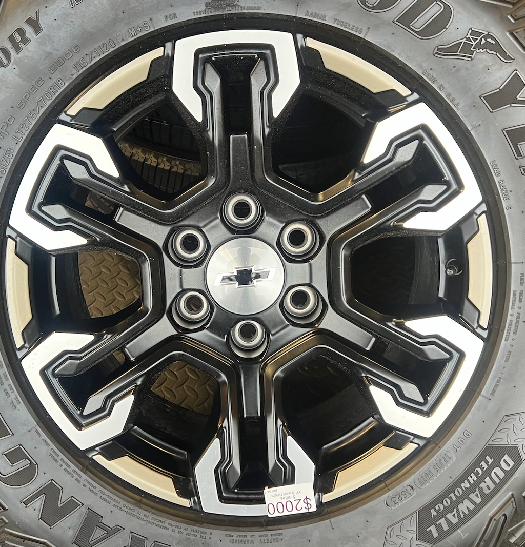 OEM 18” Gloss Black Machined Face Chevrolet Wheels wrapped in Goodyear Wrangler Territory M/T tires.