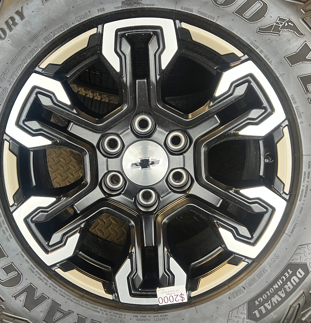 OEM 18” Gloss Black Machined Face Chevrolet Wheels wrapped in Goodyear Wrangler Territory M/T tires.