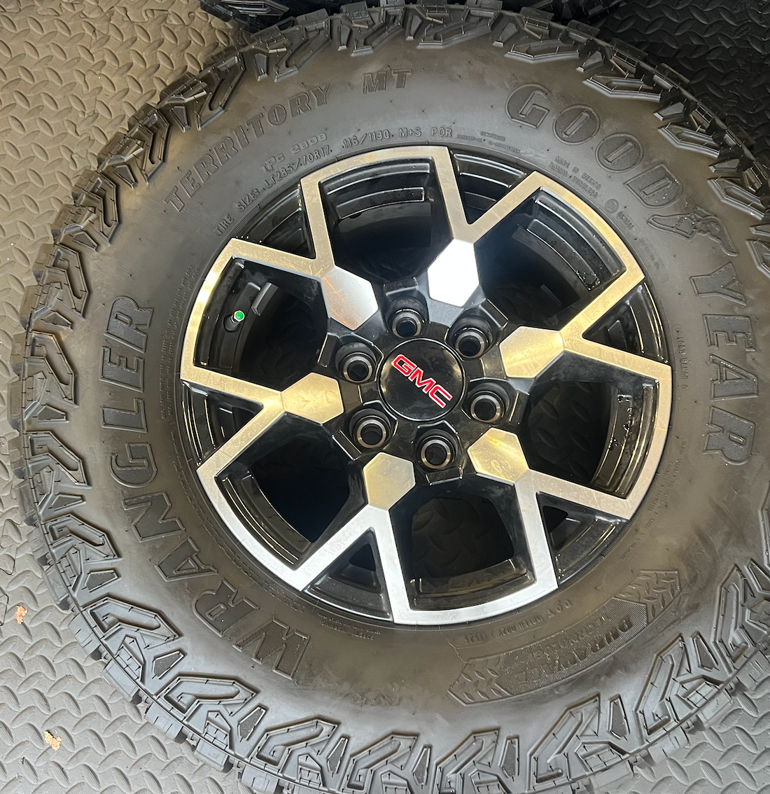 OEM 17”  Wheels with Black & Machined Finish wrapped in Goodyear Wrangler Territory M/T tires.