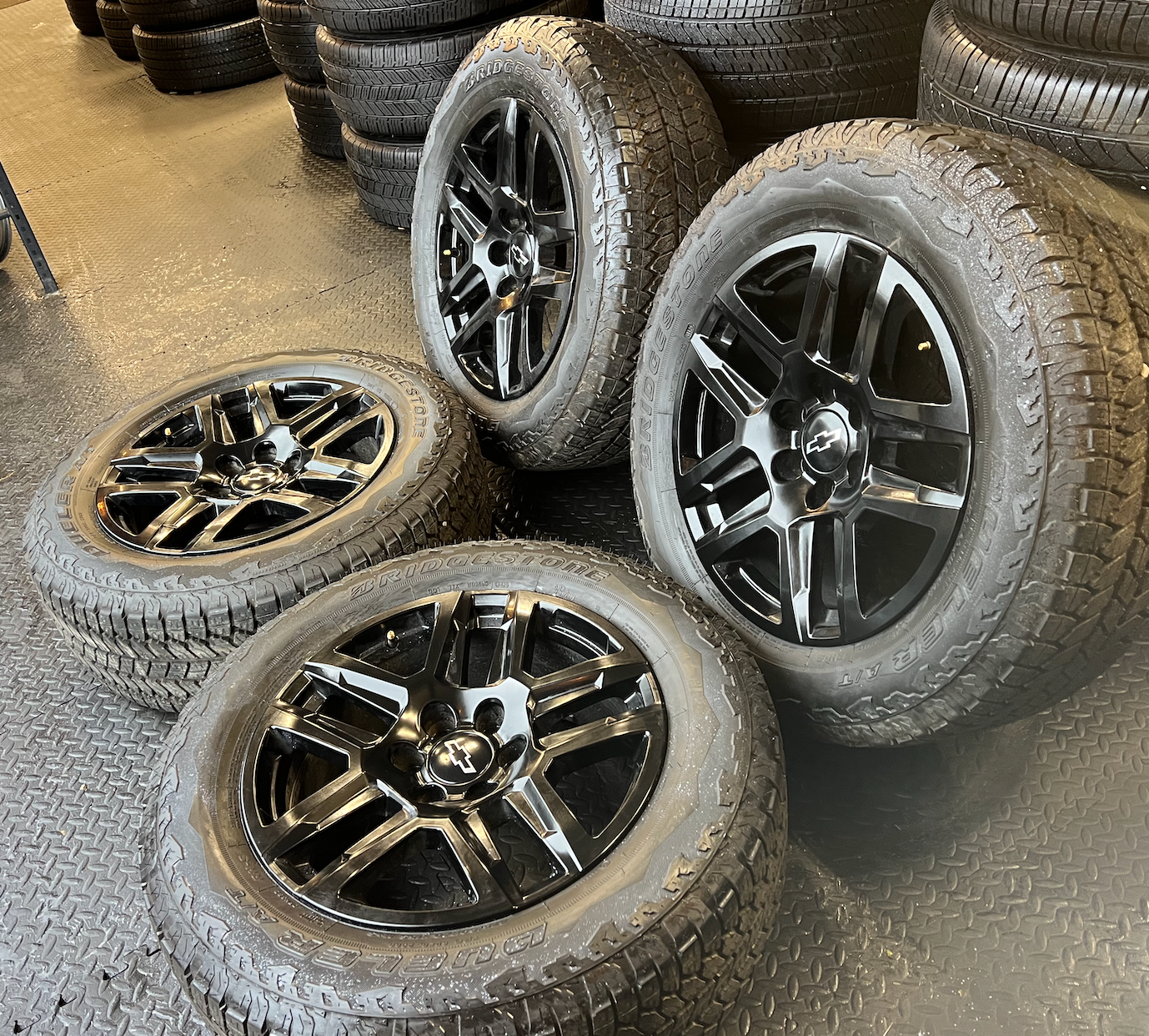 OEM 20” Gloss Black Wheels wrapped in Bridgestone Dueler A/T tires.