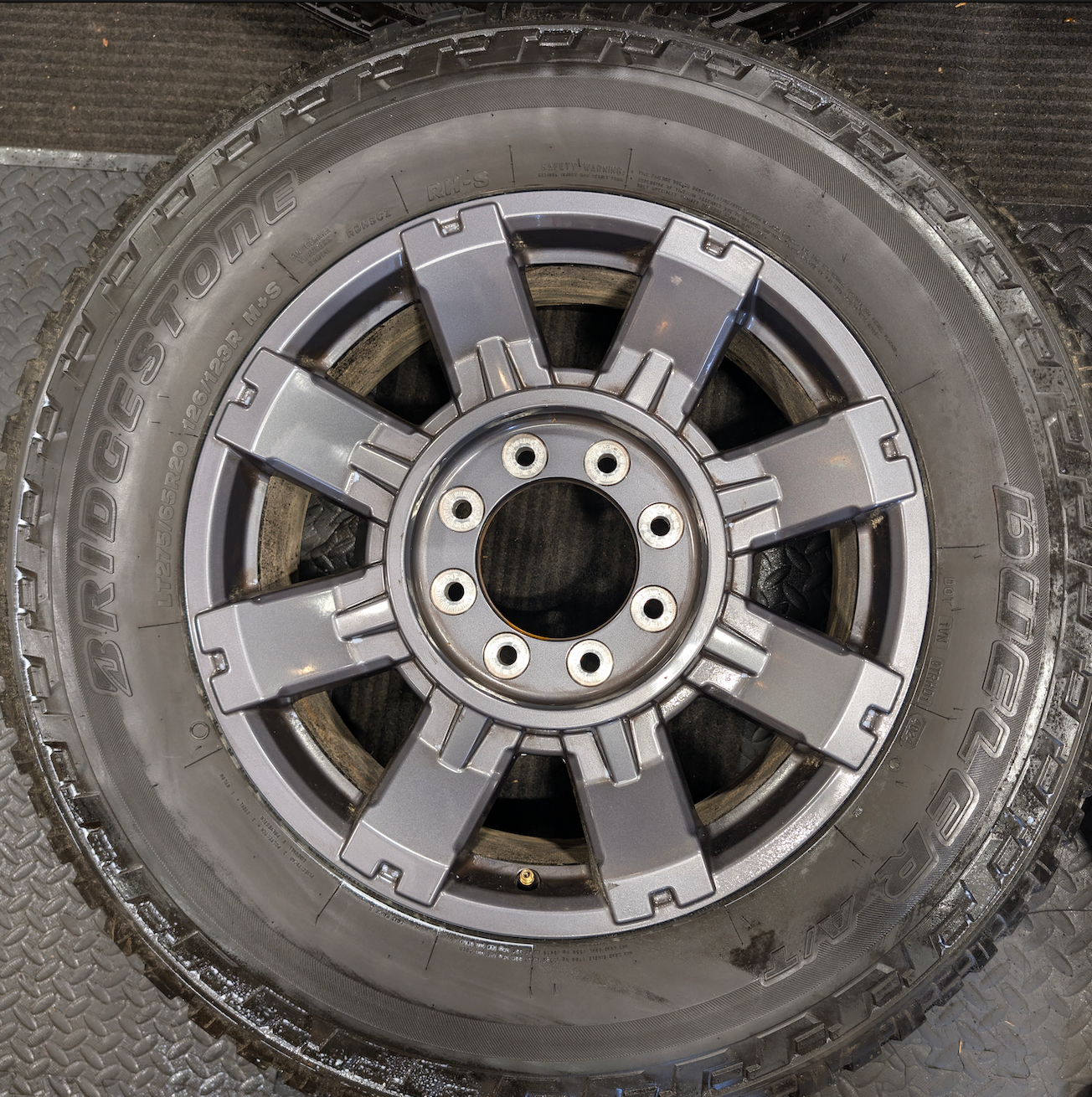 OEM 20” Dark Carbonized Gray Ford F-250 / F-350 Super Duty Wheels wrapped in Bridgestone Dueler tires.