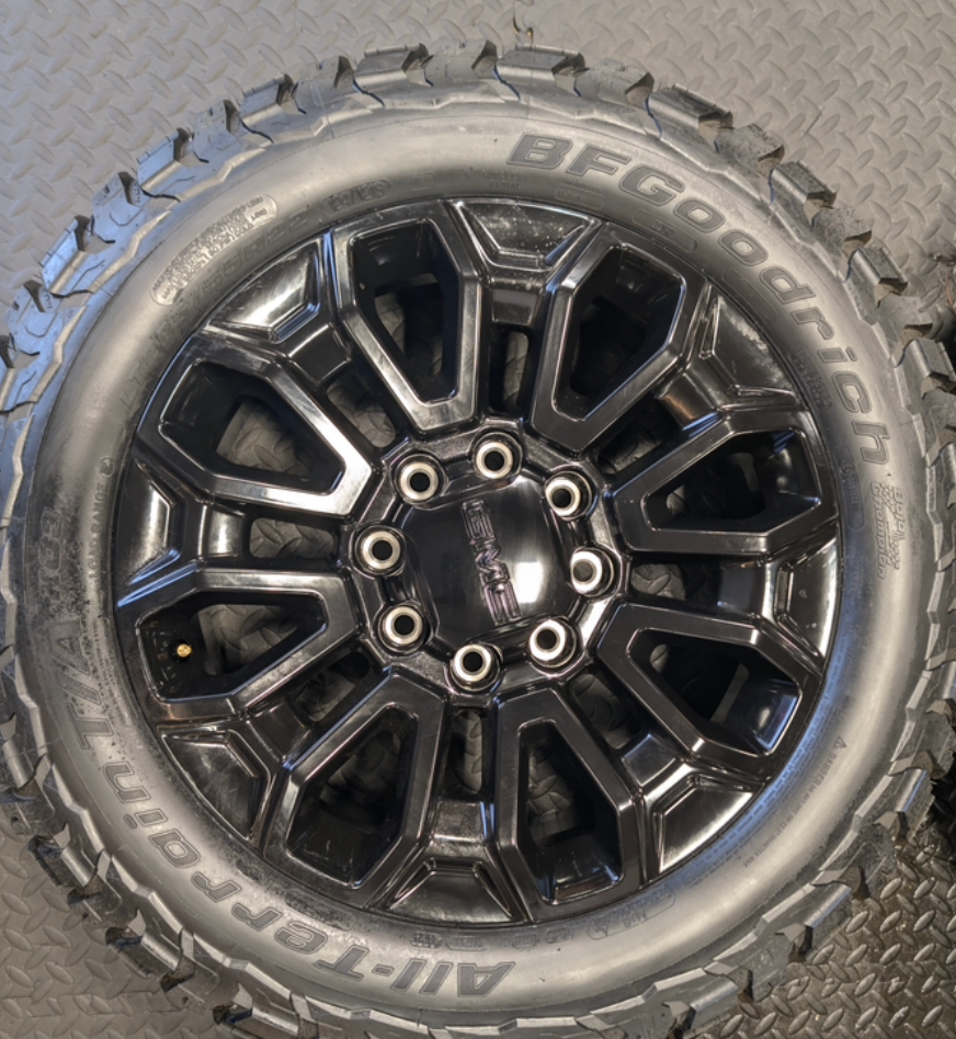 OEM 22” Gloss Black GMC Sierra 2500HD / 3500HD Wheels wrapped in BFGoodrich All-Terrain T/A KO2/KO3 tires.