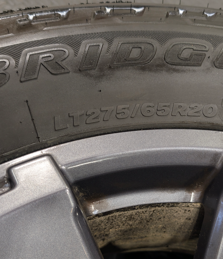 OEM 20” Dark Carbonized Gray Ford F-250 / F-350 Super Duty Wheels wrapped in Bridgestone Dueler tires.