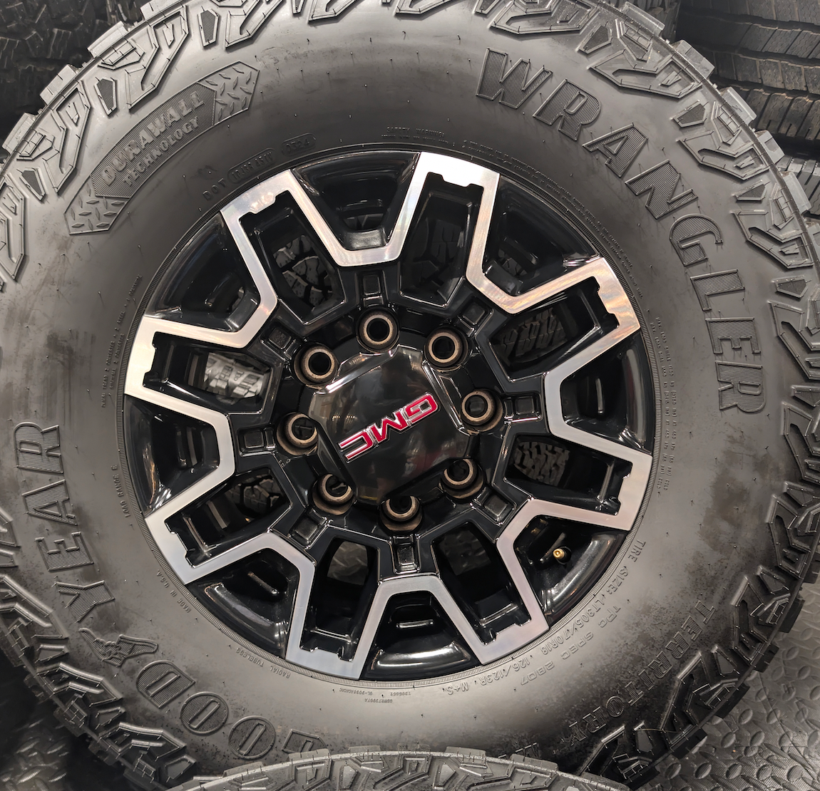 OEM 18” GMC Sierra 2500HD AT4X Black Wheels wrapped in Goodyear Wrangler Territory M/T tires.