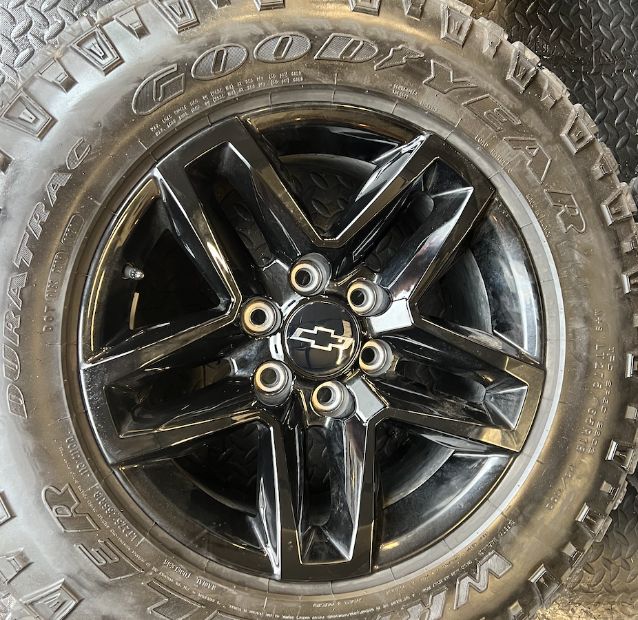 OEM 18” Gloss Black Trail Boss Wheels wrapped in Goodyear Wrangler Duratrac tires.