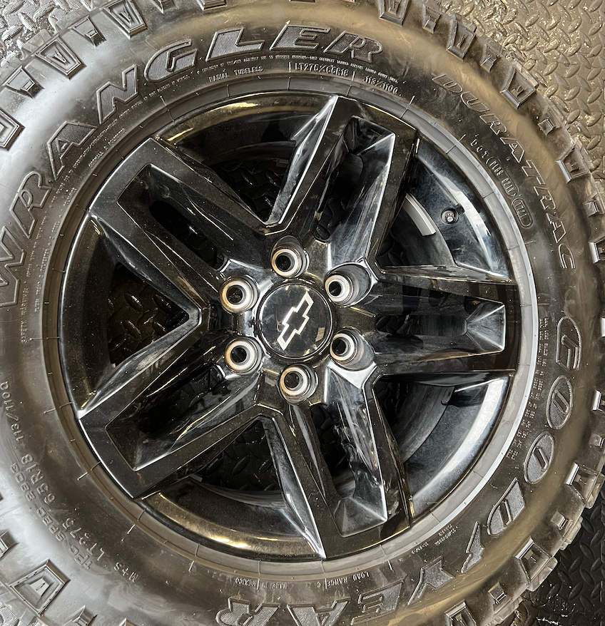 OEM 18” Gloss Black Trail Boss Wheels wrapped in Goodyear Wrangler Duratrac tires.