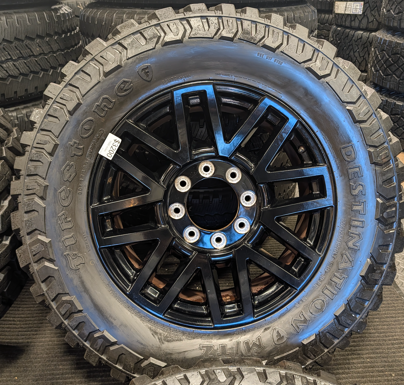 OEM 20” Gloss Black Ford F-250 / F-350 Super Duty Wheels wrapped in Firestone Destination M/T2 tires.