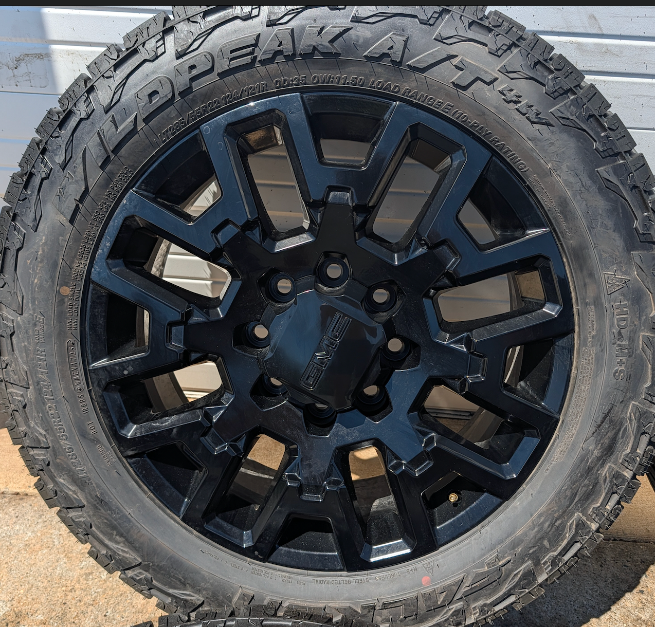 OEM 22” Gloss Black GMC HD Wheels with Split-Spoke Design wrapped in LT285/55R22 Falken Wildpeak A/T4W tires.