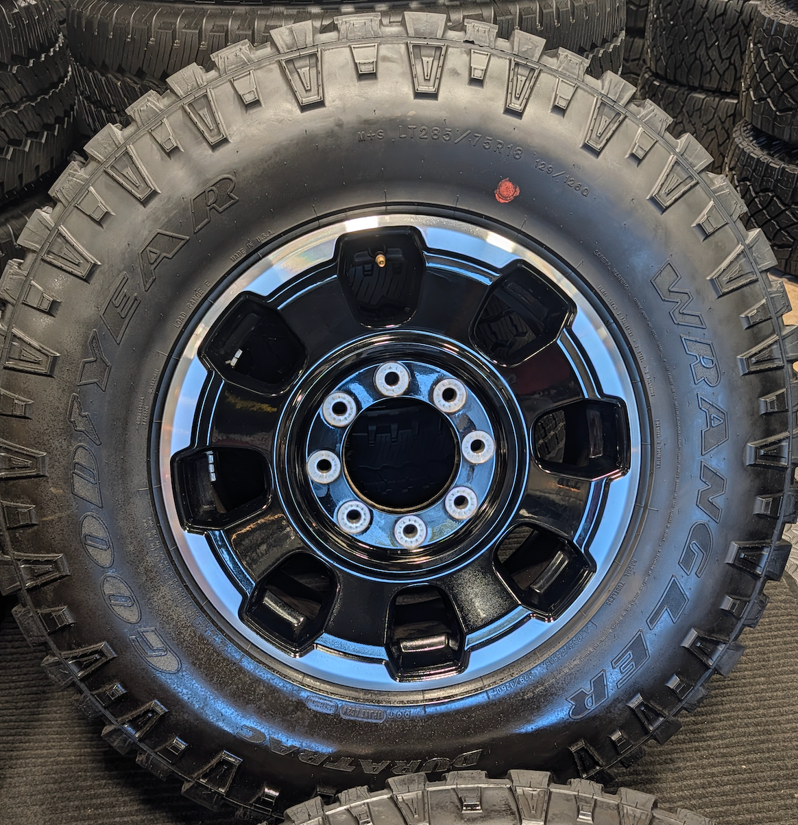 OEM 18” Gloss Black Machined Ford F-250 / F-350 Tremor Wheels wrapped in LT285/75R18 Goodyear Wrangler DuraTrac tires.