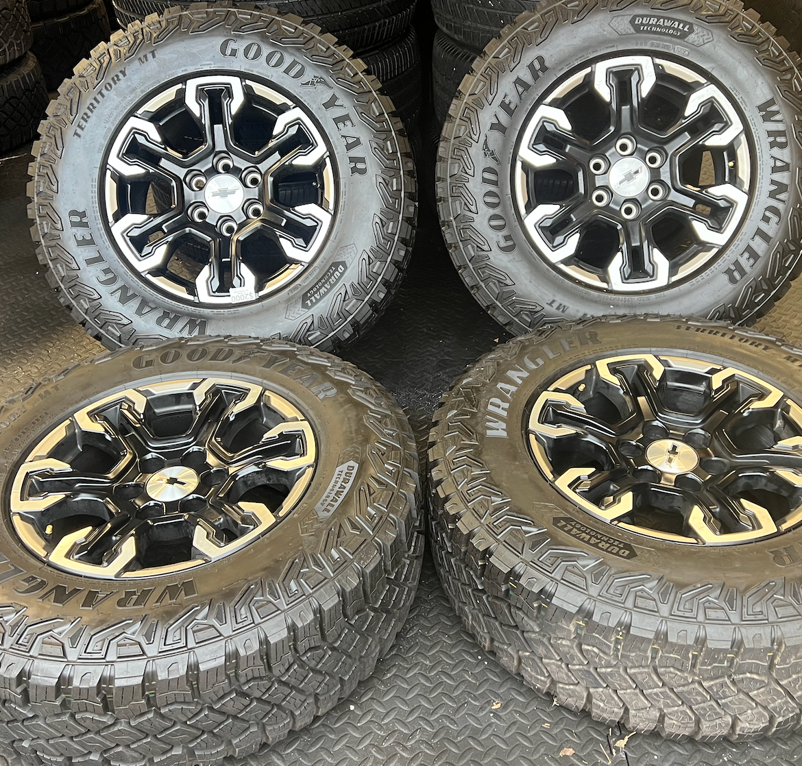 OEM 18” Gloss Black Machined Face Chevrolet Wheels wrapped in Goodyear Wrangler Territory M/T tires.