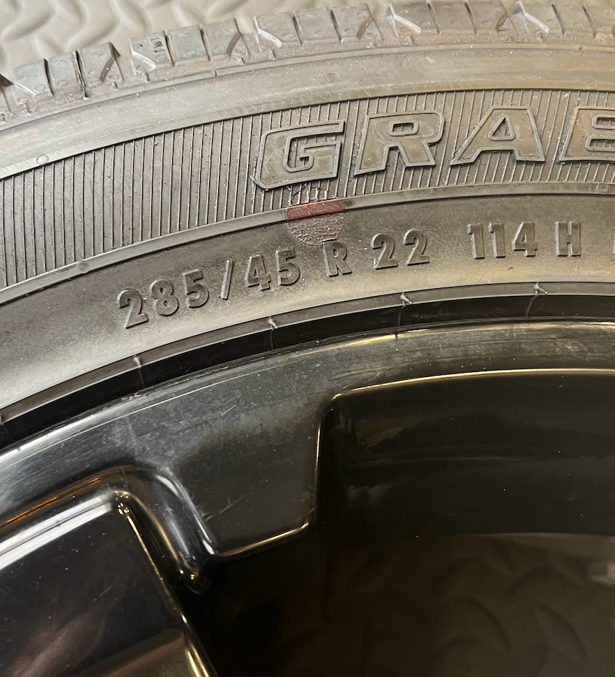 OEM 22” Gloss Black Wheels wrapped in General Grabber tires.