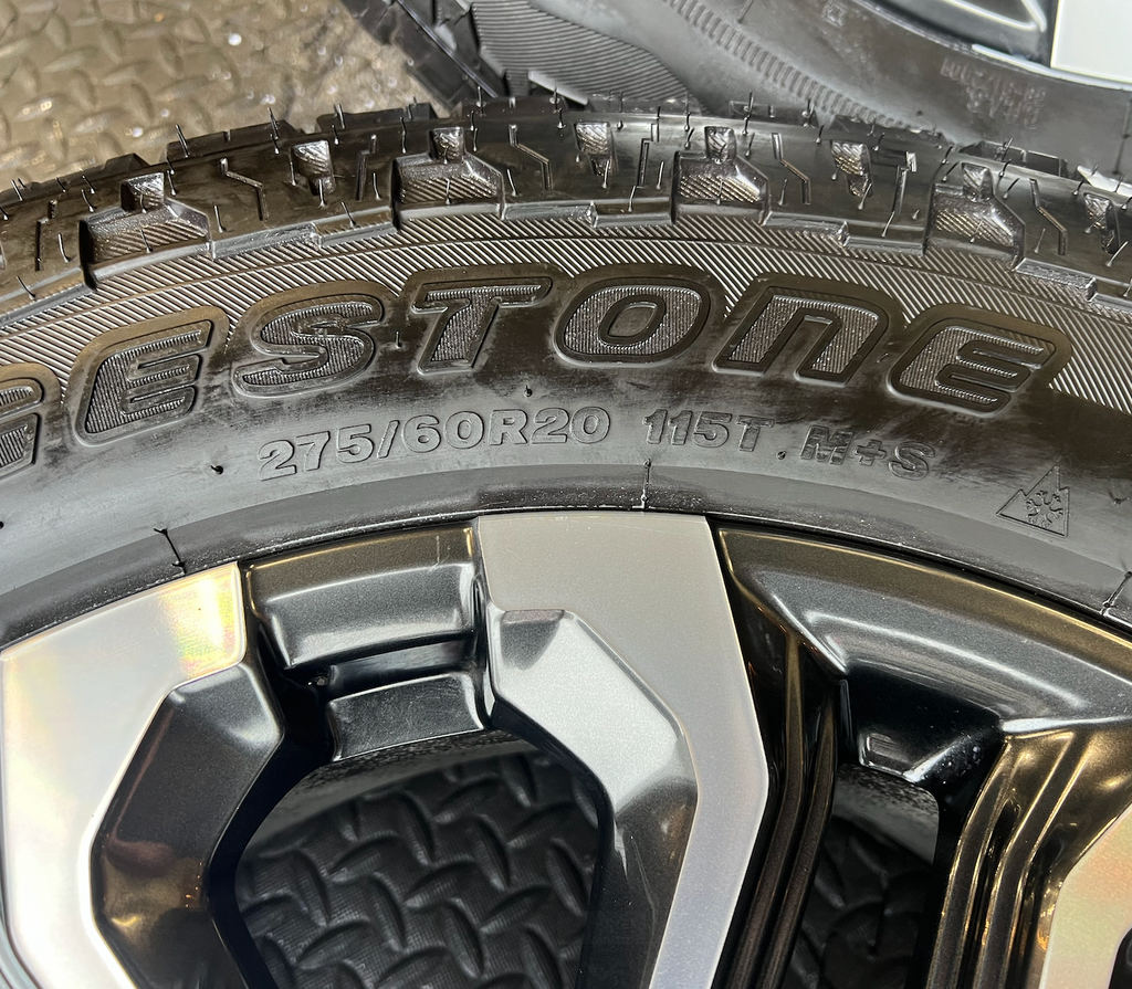 OEM 20” Charcoal Machined Wheels wrapped in Bridgestone Dueler A/T tires.