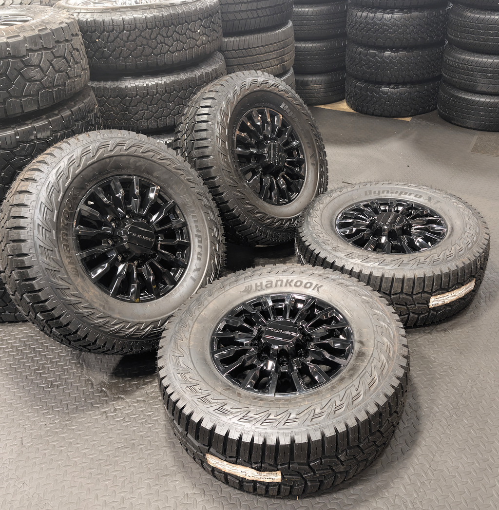 OEM 18” Gloss Black GMC Sierra / Chevrolet Silverado 2500HD & 3500HD Wheels wrapped in Hankook Dynapro XT tires.