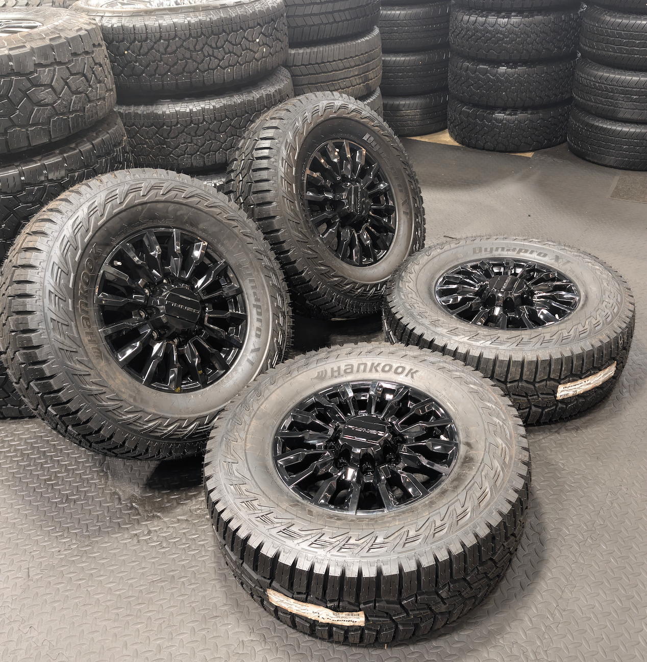 OEM 18” Gloss Black GMC Sierra / Chevrolet Silverado 2500HD & 3500HD Wheels wrapped in Hankook Dynapro XT tires.