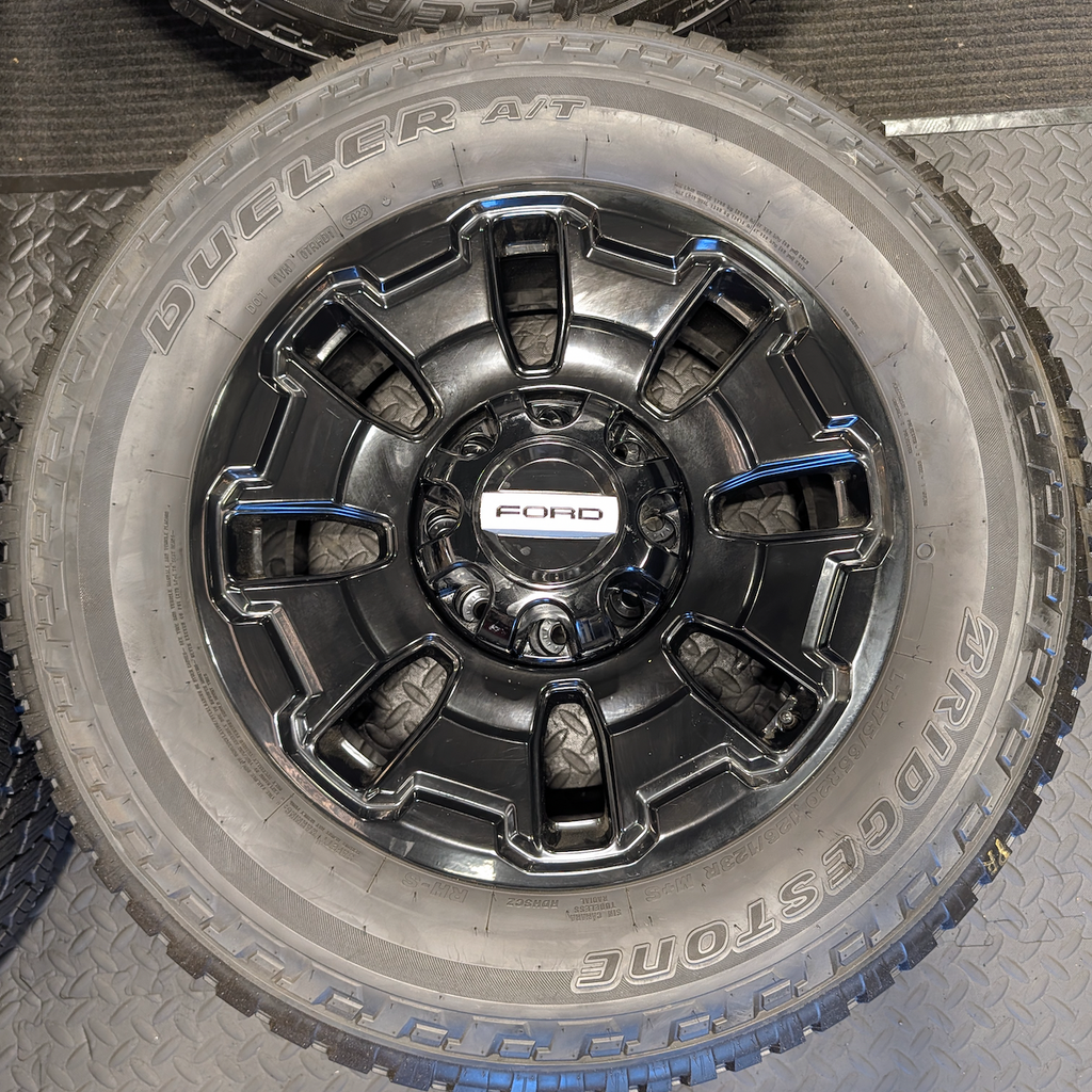 OEM 18” Ford F-250 / F-350 Tremor Wheels with Gloss Black Finish wrapped in Bridgestone Dueler A/T tires.