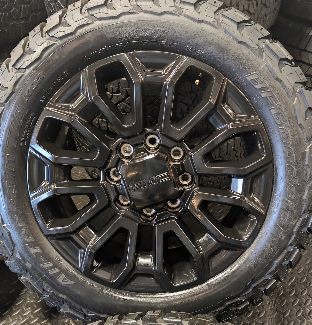 OEM 22” Gloss Black GMC Sierra 2500HD / 3500HD Wheels wrapped in BFGoodrich All-Terrain T/A KO2/KO3 tires.