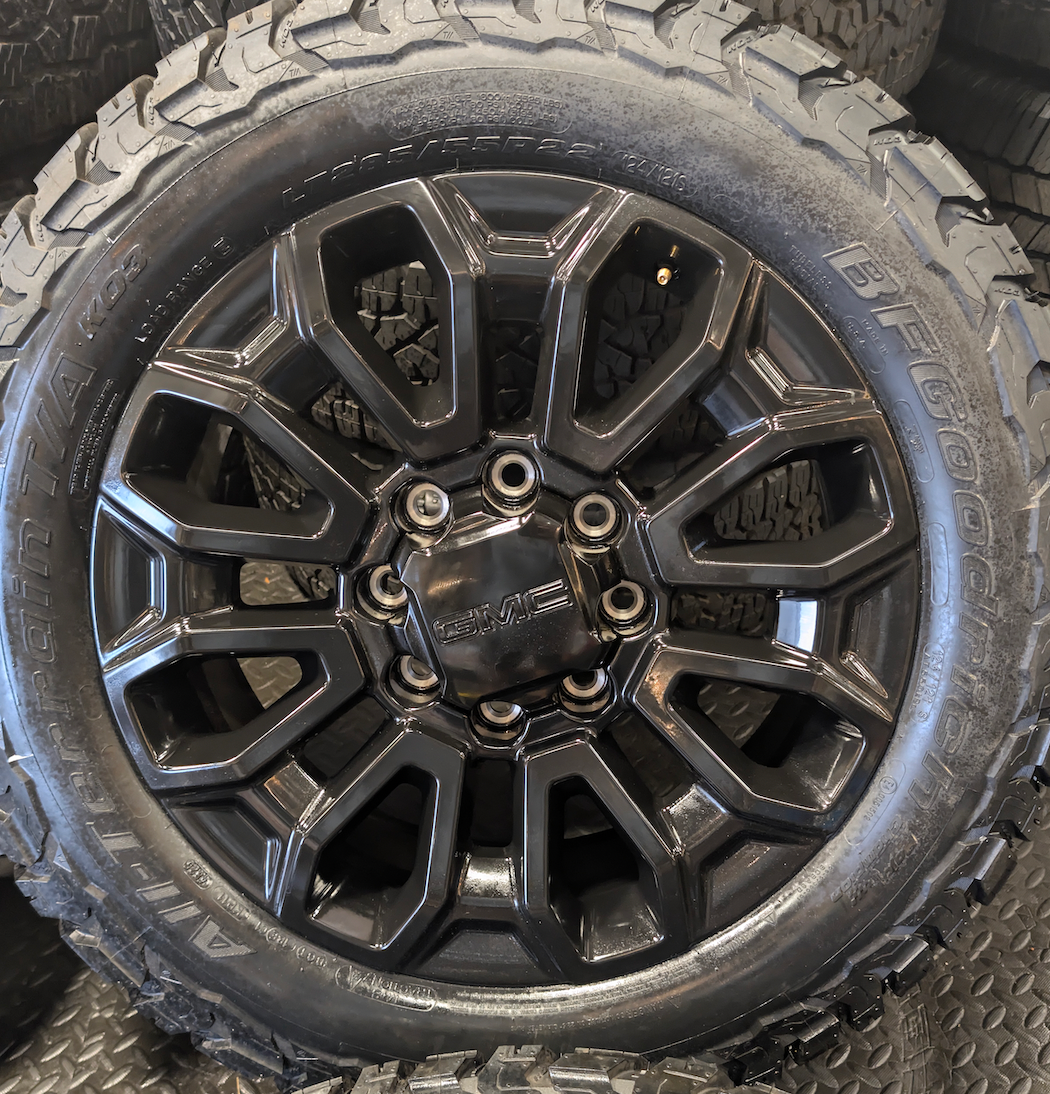 OEM 22” Gloss Black GMC Sierra 2500HD / 3500HD Wheels wrapped in BFGoodrich All-Terrain T/A KO2/KO3 tires.