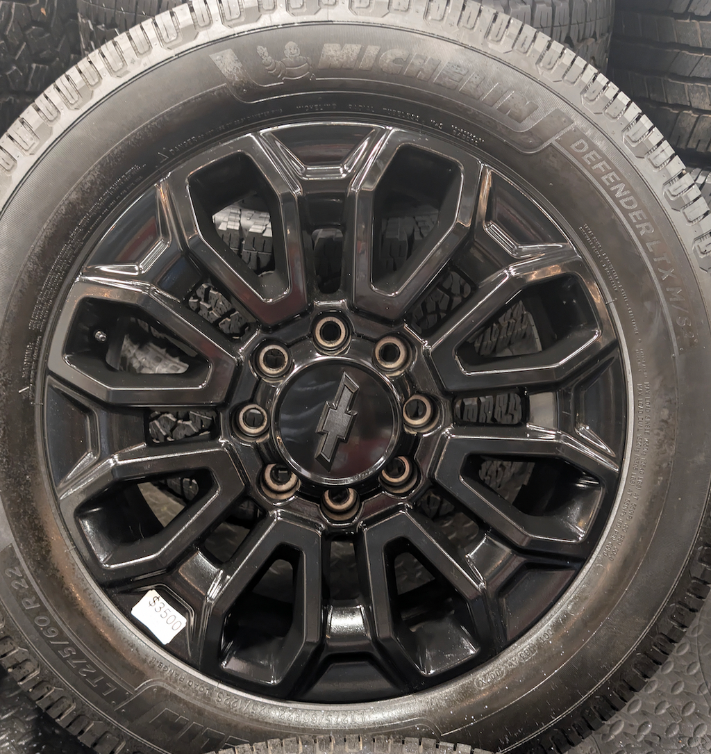 OEM 22” Gloss Black Chevrolet Silverado 2500HD / 3500HD Wheels wrapped in Michelin Defender LTX tires.