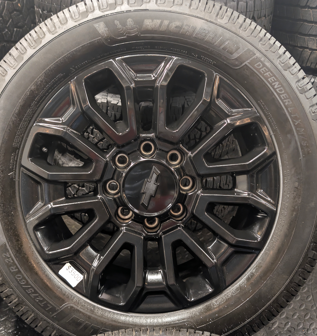 OEM 22” Gloss Black Chevrolet Silverado 2500HD / 3500HD Wheels wrapped in Michelin Defender LTX tires.