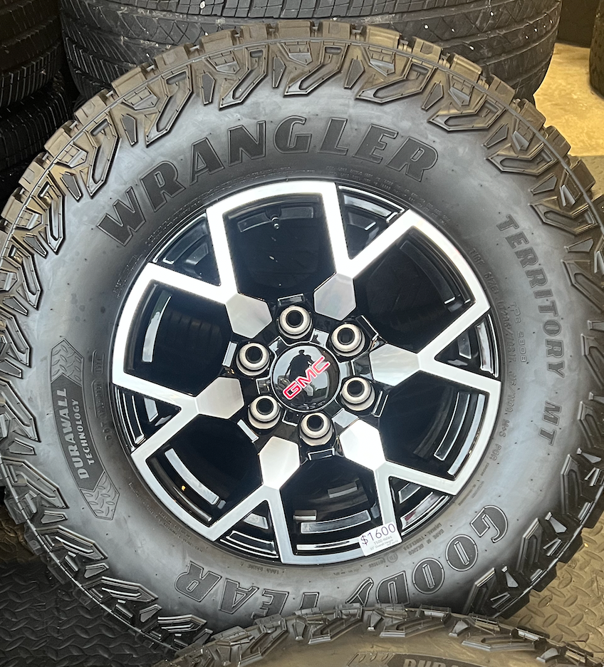 OEM 17”  Wheels with Black & Machined Finish wrapped in Goodyear Wrangler Territory M/T tires.